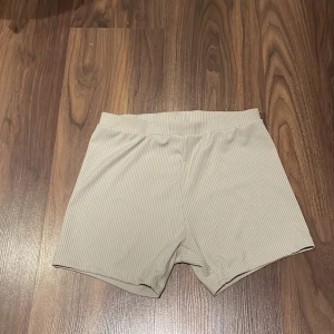 Träningsshorts  - Säljer ett par ribbade träningsshorts i storlek S. Shortsen är en tajt modell och lite glansiga och ribbade i materialet. De kommer från början från Lager157 och är i bra skick. 
