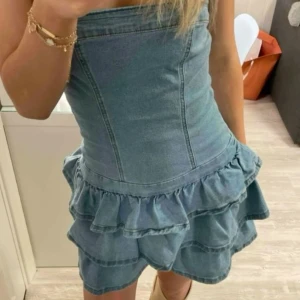 Jeansklänning med volanger - Jättesnygg och trendig jeansklänning som sitter åt i midjan och formar kroppen så snyggt!!! Perfekt nu till sommaren