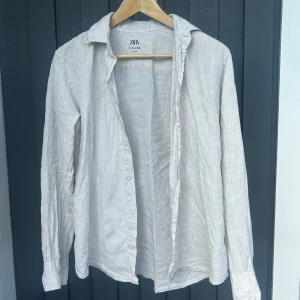 Ljusbeige linneskjorta från Zara (storlek S) passar xs - Säljer en ljusbeige skjorta från Zara i 100% linne. Skjortan har lång ärm, klassisk krage och knäppning framtill. 