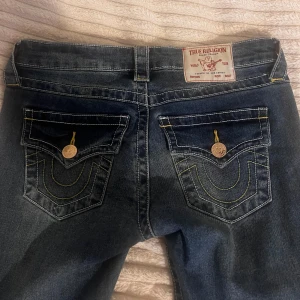 True Religion blå bootcut jeans - NYA oanvända flare true religion jeans från Nelly! INGA DEFEKTER! Orginalpris är 1400kr men säljer för 500kr billigare. Snygga och passar till allt!😍💕Säljer pga jag har för många jeans. Strl: W24
