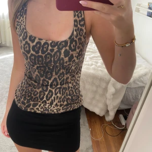 Leopardmönstrad tight linnetopp - Säljer en snygg leopardmönstrad med djup urringning. Toppen är tight och har breda axelband. Perfekt för dig som vill sticka ut med ett trendigt mönster.