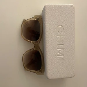 Beige solglasögon från CHIMI - Snygga solglasögon från CHIMI i modellen 07, färg ecru. De har en transparent beige båge och mörka glas. Perfekt accessoar för att lyfta din stil. Skriv gärna om ni har frågor💕