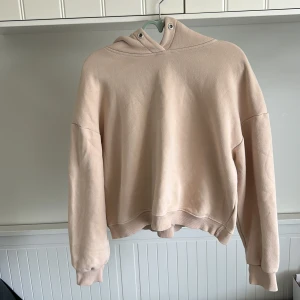 Beige hoodie med croppad passform - Säljer en beige hoodie med croppad modell och långa ärmar. Tröjan har en klassisk huva och ribbade muddar vid ärmslut och nederkant. Perfekt för en avslappnad stil. Pris går att diskutera 