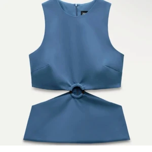 Blå croppad topp med ringdetalj - Säljer en blå croppad topp från Zara med ärmlös design och cool ringdetalj framtill som skapar en öppen midja. Toppen har en stilren, rak form och stängs med dragkedja i ryggen. Perfekt för dig som vill sticka ut med en trendig look.