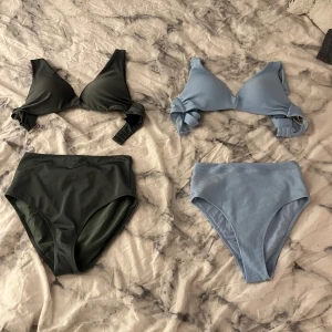 Två bikinis med hög midja - Säljer två snygga bikinis med hög midja, en i mörkgrönt och en i ljusblått ribbat tyg. Båda har vadderade kupor och knyt-detaljer på axelbanden. Perfekt för strandhäng eller poolparty i sommar! Båda för 50