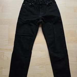 Svarta loose jeans från Grunt storlek 152 (25) - Svarta jeans från Grunt i modellen Street Loose Night. De har en loose passform med raka ben och klassisk femficksdesign. Jeansen är tillverkade i ett mjukt bomullstyg och har midjehög skärning. Perfekta för en avslappnad streetstil.