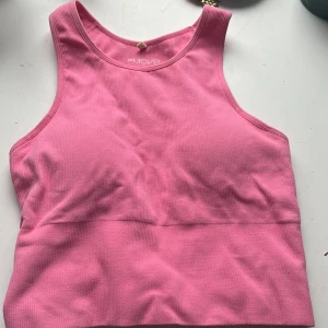 Rosa ribbad linnetopp H&M Move S - Säljer en rosa ribbad linnetopp från H&M Move i storlek S. Toppen har sportig look med breda axelband och rund halsringning. Perfekt för träning eller chill dagar. Materialet är stretchigt och mjukt mot huden. Knappt använd 