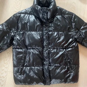 Svart pufferjacka - Säljer en svart glasig pufferjacka❤️ lite sliten här och var men inget man tänker på❤️använd en vinter och är i relativt bra skick❤️ nypris 600 kr❤️
