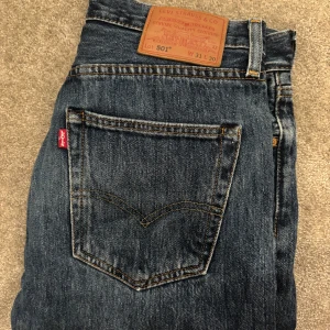 Levi's 501 blå jeans straight fit - Klassiska Levi's 501 jeans i blå denim med raka ben och normal passform. Byxorna är knappt använda och skulle säga 9/10 i cond. Storlek som ni ser på bilden W31 L30 passar mig perfekt som är 180 och väger 70kg