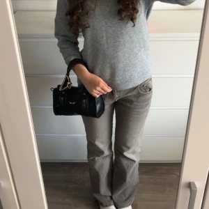 Grå bootcut jeans från Perfect Jeans - Säljer ett par gråa bootcut jeans från Perfect Jeans i storlek 38. Jeansen har klassisk femficksdesign, dubbla knappar i midjan och bakfickor med lock och knapp. Snygg tvättad grå färg och skön passform med lite utsvängda ben.