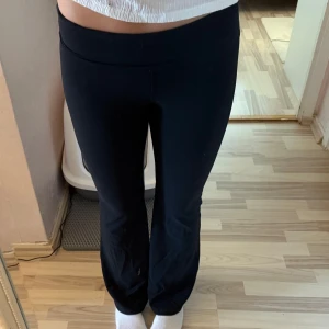 Svarta tränings byxor  - Säljer ett par svarta bootcut byxor med låg midja. De har en skön och stretchig passform som sitter tajt upptill och släpper ut vid benen. Perfekta för en chill och snygg look.
