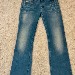 Diesel jeans - Utsvängda Lågmidjade diesel jeans. Väldigt snygga Lågmidjade utsvängda jeans från diesel, tyvärr lite för korta för mig som är 171. Mått, Midja: 78 cm Gylf: 21 cm Innerben:36 Längd: 95 cm 