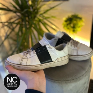 Valentino Garavani skor  - Snygga Valentino Garavani sneakers i vitt med en bred svart band över sidan.😍 Skorna är slitna mest bara färg som lossnat men ändå helt okej skick.🔥 Skick 6/10. Sulan har haft hål med de är limmat och fixat. Original Skoboxen följer med. 👑 byten går. Inget fast pris. Storlek 42 men passar nog 41-43, Fråga om ni undrar något!🤩🙏