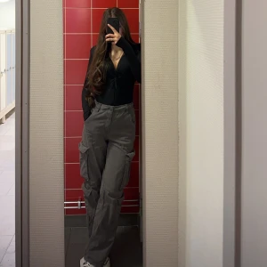 Grå cargobyxor med snörning - Säljer ett par grå cargobyxor med flera stora fickor på sidorna och snörning i midjan. Byxorna har en loose passform och är perfekta för en avslappnad stil. Använd några gånger men är i väldigt bra kick 