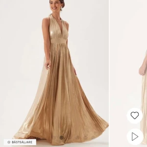 Guldig långklänning med halterneck - Säljer en glansig guldig långklänning med halterneck och öppen rygg. Klänningen har ett vackert fall och markerad midja, perfekt för bal eller fest. Materialet är skimrande och ger en lyxig känsla. Helt ny och aldrig använd. Säljer åt en vän. 😊hör av er för frågor