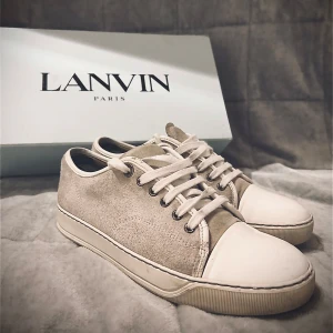 Lanvin Cap-Toe - Ett par schyssta skor från Lanvin med en mer beige ton på mockan och vita detaljer som matchar strålande med snörena. Fint skick, väldigt små defekter som ej syns vid användning. Vid frågor, funderingar och prisförlsag skicka privat! Byten kan också vara intressant.🍾