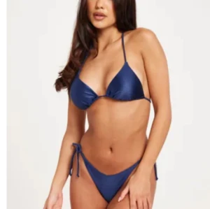 Mörkblå bikini med knyt - Snygg mörkblå bikini med trekantsöverdel och knyt i sidorna på underdelen. Klassisk modell med tunna axelband och enkel design, perfekt för stranden eller poolen. Aldrig använd 