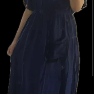 Marocan/ sommar klänning - Säljer en elegant mörkblå långklänning med fina broderade detaljer och korta ärmar. Klänningen har en luftig passform och markerad midja, perfekt för speciella tillfällen.