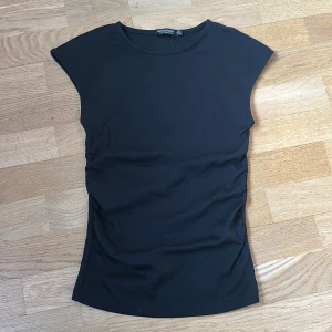 Svart ärmlös topp från Stradivarius - En stilren svart ärmlös topp från Stradivarius med rund halsringning och figurnära passform. Perfekt att matcha med jeans eller kjol för en enkel och snygg look.