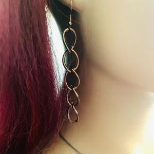 By prisförslag- 1 st Långt örhänge i guldtonad metall - Ett örhängen i guldtonad metall. Den har en spiralformad design med flera sammanlänkade öglor som ger ett coolt och trendigt intryck. Perfekt för dig som vill sticka ut med dina accessoarer!