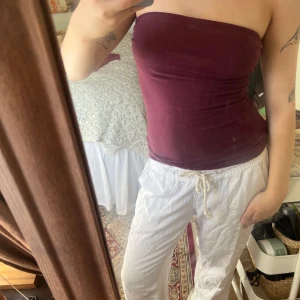 Vinröd tubtopp från H&m basic  - Säljer en vinröd tubtopp i mjukt och stretchigt material. Toppen är axelbandslös och sitter tight mot kroppen, perfekt för sommardagar eller som layering-plagg. Enkel och stilren design utan synliga detaljer. Tubtopp en är i st S och i stretchigt material!💜🩷