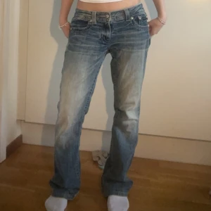 Lågmidjade Miss Me bootcut jeans - Jätte snygga blå bootcut jeans från Miss Me med dekorativa detaljer och broderier på bakfickorna💗. Jeansen har en klassisk femficksdesign och en dragkedja.💕💕Midja: 41 cm (rakt över), Längd: ungefär 78 cm (tror jag).🥰