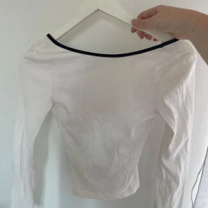 Vit topp - Säljer en vit så fin vit långärmad topp med svart kant runt . Toppen är ribbad och har en tight passform🩷🩷 strl xxs/xs/s , passar mig som är 170 cm!