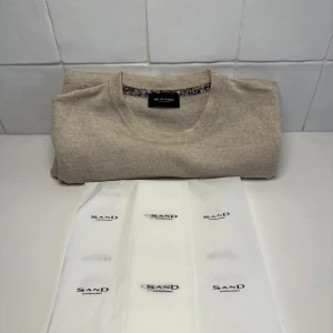 Beige tröja från Sand - Säljer en stilren beige tröja från Sand. Tröjan har långa ärmar och en rund halsringning. Perfekt för en avslappnad och elegant look. Tröjan är imprencip helt ny (bara testad). Bara att höra av sig till oss vid minsta fundering😁