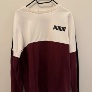 Bordeaux och vit sweatshirt från Puma - Säljer en snygg sweatshirt från Puma i bordeaux och vitt. Tröjan har lång ärm, rund halsringning och Puma-loggan. Perfekt för en avslappnad stil. Kan du gå ner i pris vid snabb affär!💕