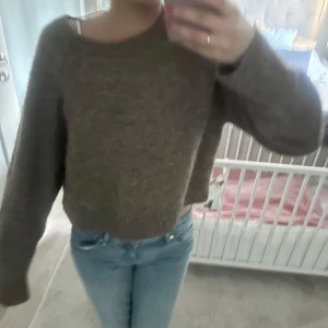 Brun croppad stickad tröja - Mysig brun stickad tröja med croppad passform och långa ärmar. Tröjan har en enkel design och är perfekt för lager-på-lager-stil. Passar till jeans eller kjol för en avslappnad look.