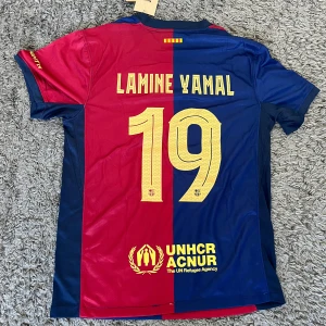 Barcelona hemmaställ 24/25 Lamine Yamal - STORLEK M. Snygg Barcelona  fotbollströja med Lamine Yamal och nummer 19 på ryggen Nike logga och Spotify som sponsor framtill. Materialet är lätt och andas, perfekt för sommaren. Helt ren. PRISET KAN DISKUTERAS.