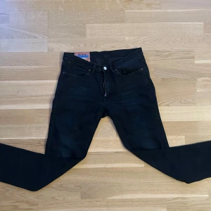 Acne studio jeans - Säljer ett par mörk blåa jeans från Acne Studios Blå Konst. Klassisk femficksmodell med raka ben och normal passform. Jeansen har en snygg detalj med Acne Studios-märke bak i midjan. Perfekta för dig som gillar stilrena och tidlösa jeans. Strlk 31-32