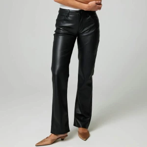 Svarta skinnbyxor med rak passform - Snygga svarta byxor skinnbyxor med hög midja och raka ben. Klassiska med dragkedja och knapp framtill. Perfekta för en trendig och stilren look.