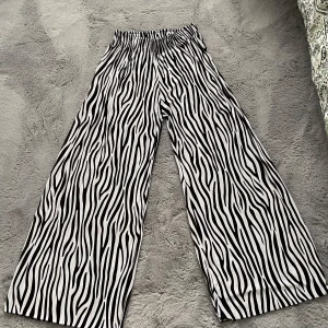 Zebramönstrade vida byxor - Söta zebramönstarde byxor. Luftiga och vida så perfekta under varmt väder. Väldigt stretchiga midja alltså kan passformen vara olika. Skriv gärna ifall ni vill ha fler bilder eller undrar något särskilt över storleken🥰💗💝