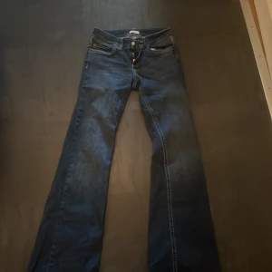 Mörkblå bootcut jeans med broderade bakfickor - Säljer ett par fina mörkblå bootcut jeans med så skönt material. Använda endast ett fåtal gånger. Nypris 700kr