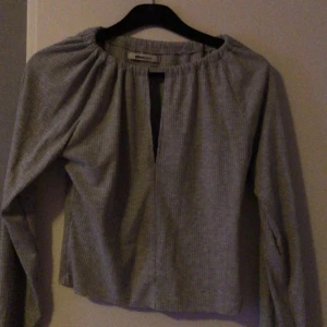 Grå ribbad långärmad topp från Gina Tricot - Säljer en grå ribbad långärmad topp från Gina Tricot med en snygg öppning vid brösten:) Mjuk, bekväm och rätt så stretching tröja.             30kr plus frakt :)