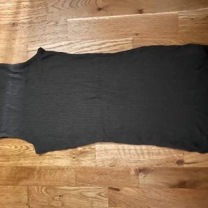 Grön ribbad långklänning från Gina Tricot - Säljer en mörk grön ribbad långklänning från Gina Tricot. Klänningen har en tight passform och är ärmlös, perfekt för en stilren och enkel look. Materialet är stretchigt och följsamt.