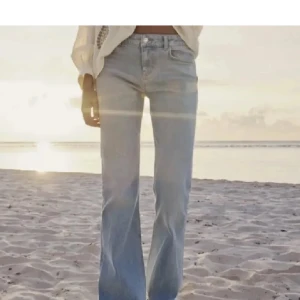 Ljusblå bootcut jeans - Säljer ett par ljusblå bootcut jeans med klassisk femficksdesign och knappgylf. Jeansen har en snygg, något utsvängd passform och är perfekta för en avslappnad stil. Kontakta för fler bilder