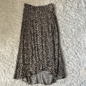 Leopardmönstrad långkjol från Lindex - Säljer en snygg leopardmönstrad långkjol från Lindex. Långkjolen har en rak passform och är i mjukt, lätt material som faller fint. Perfekt för dig som gillar djurmönster och vill sticka ut lite extra.