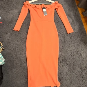 HELT NY Långärmad off-shoulder klänning  - En långärmad off-shoulder klänning från Boohoo med volangdetalj längs halsringningen. Klänningen har en figurnära med en längre passform. Några lösa trådar, men annars helt ny och oanvänd med prislapp kvar. Mer rosa irl, storlek 36 och passar både Xs och S.