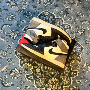 Nike Air Jordan 1 High Dark Mocha - Säljer mitt par Nike Air Jordan 1 High Dark Mocha då de stått i garderoben alldeles för länge. Små tecken på användning vid toeboxen annars väldigt fint skick, mockan i sig har torkat en del eftersom de bara stått under en lång period men enkelt att borsta upp. Skriv vid frågor, snabb affär prioriteras då jag vill bli av med dessa, priset går att diskutera. Box finns.