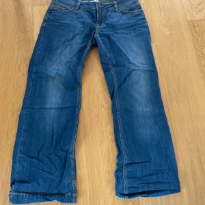 Blå jeansbyxor från De.corp Esprit Urban Casual - Säljer ett par klassiska blå jeansbyxor från De.corp Esprit Urban Casual med raka ben och kontrastsömmar. Byxorna har normal passform och är perfekta för en avslappnad stil. Midjan är normal och materialet är slitstarkt denim.