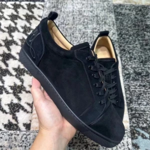 Svarta sneakers från Christian Louboutin med röd sula - Säljer ett par svarta sneakers i mocka från Christian Louboutin med den ikoniska röda sulan. Skorna har snörning och rund tå, samt diskreta detaljer på hälen. Perfekta för dig som vill ha en stilren och lyxig look.