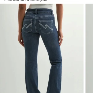 Nelly jeans  - Snygga blå bootcut jeans med vita kontrastsömmar och klassiska bakfickor med broderad detalj. Jeansen har normal passform och är tillverkade i denim med knapp- och dragkedjestängning framtill. Minimalt slitage nere vid fötterna