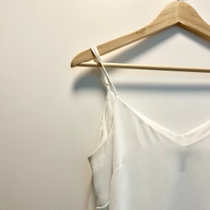 Linne - Vitt linne med justerbara axelband och en V-ringning. Linnet har en lätt och luftig design. Den har två lager. Från White House Black Market, storlek S. Fint skick. 🌸