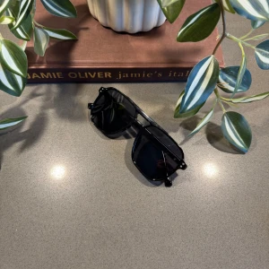 Solglasögon Retro Look - Stilrena pilotglasögon med svart ton– sommarens måste!🔥🍻 Trendiga pilotbågar i svart med svarta linser – perfekta för soliga dagar, roadtrips eller den där kust-feelingen i sommar🥂. Glasögonen är helt nya och levereras med valbart fodral i olika färger för en personlig touch.  Vad inkluderas i priset? Helt nya solglasögon med plast, valfri fodral (skriv vilken färg ni vill ha efter eller innan köp)   Specifikationer: mått finns på sista bild, UV 200 unisex