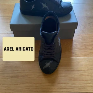  Axel Arigato Marin Blå !VINTED! - Säljer ett par svarta sneakers från Axel Arigato ”ENDAST PÅ VINTED” med snygga broderade fåglar på sidorna. Skorna har snörning och platt sula, perfekt för dig som gillar stilrena men unika detaljer.