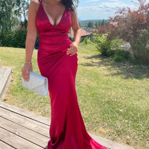 Röd balklänning med snörning i ryggen - Säljer en röd balklänning med djup v-ringning och smala axelband. Klänningen har snygg snörning i ryggen som ger en öppen rygg-effekt. (De två första bilderna är lånade) storlek: xs. Pris: 500kr, men är diskuterbart☺️