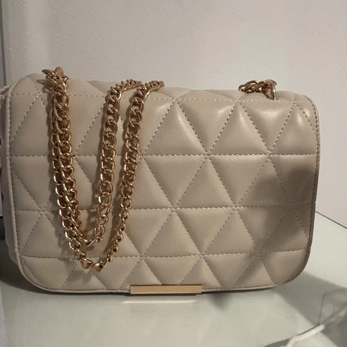 Beige quiltad axelväska med guldkedja