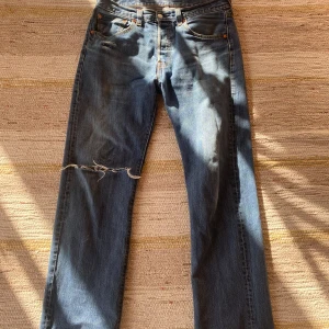 Levis 501 blå jeans med slitning - Vintage blå Levis 501 jeans med slitningar, perfekt skick inga deffekter som påverka dem dåligt. Skriv ni minsta funderingar! 